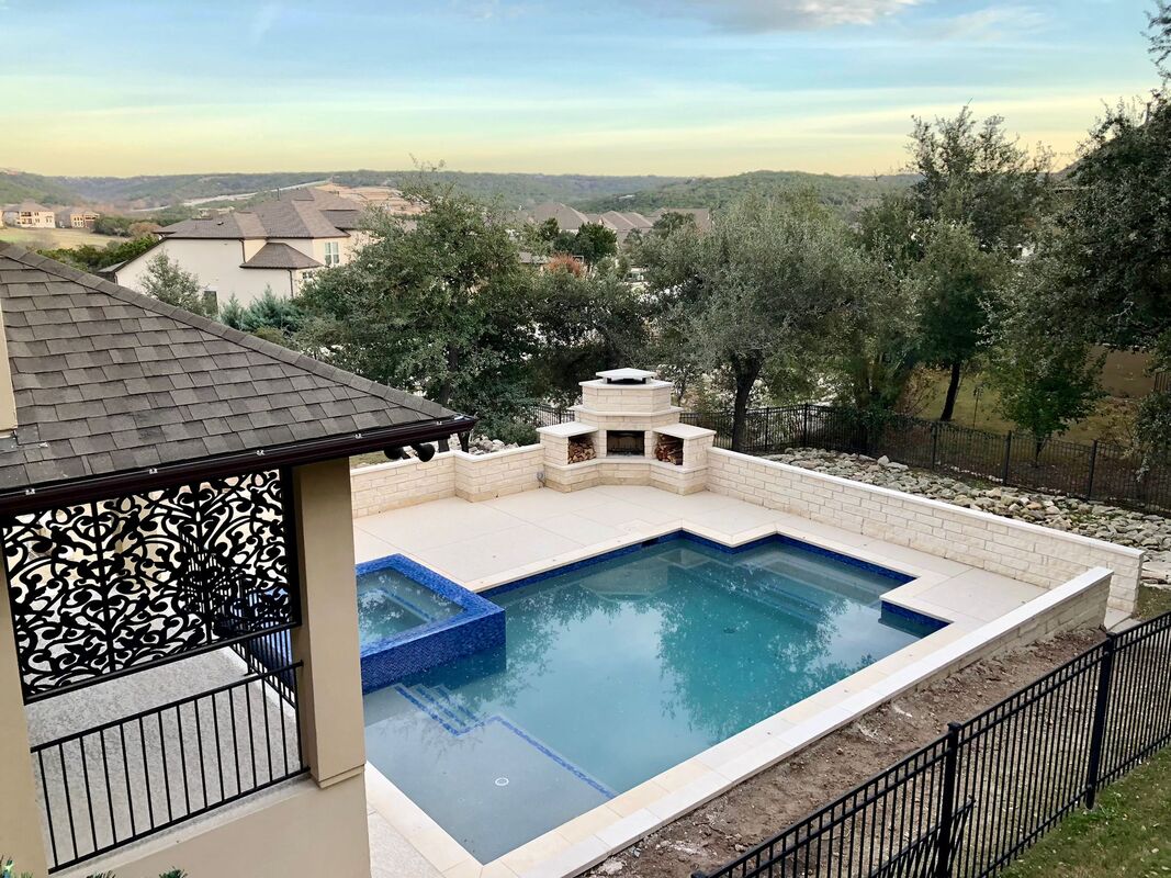Pool with covered patio, hillside view, and outdoor kitchen area