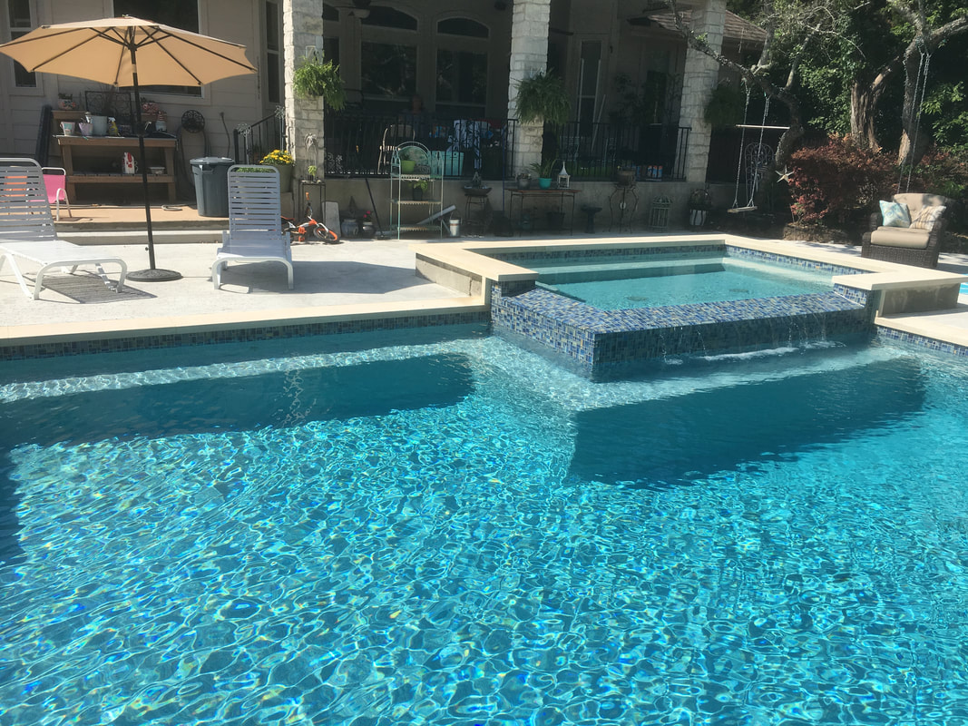 Backyard pool with a raised spa and water spillway